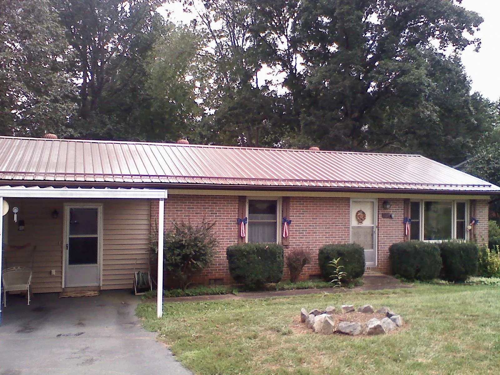 Bronze metal roof and carport on a brick ranch home — Roof Repair work by our crew in Vernon
